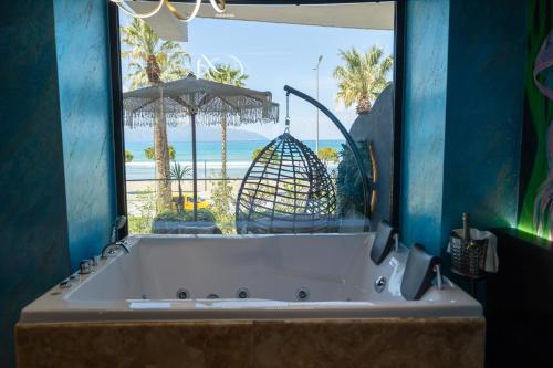 a bath tub with a view of the beach at Mustafa Suites in Vlorë