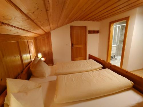 twee bedden in een kleine kamer met een raam bij Rieserhof in Heinfels