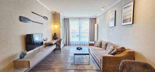 米兹多洛杰HolidayHomePL Bel Mare 317e z balkonem的客厅里有一张沙发和一台电视