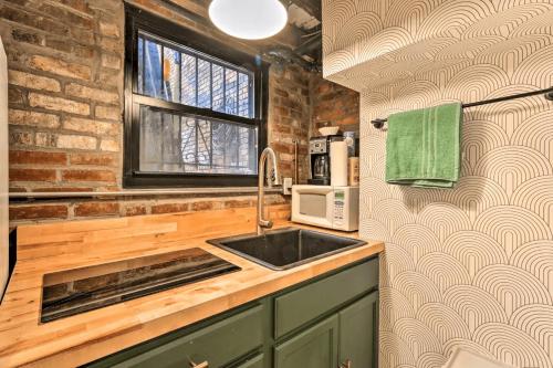 a kitchen with a sink and a brick wall at 1850s historic Row House 7min train to NYC with private backyard in Jersey City
