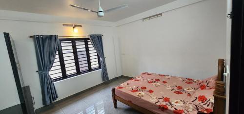 a bedroom with a bed and a window at Cherry blossom homestays Munnar 3BHK in Anachal
