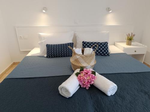 a bed with towels and a basket of flowers on it at Nautilus City Studios & Apartments in Rhodes Town