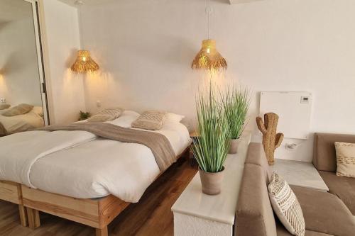 een slaapkamer met een groot bed en een bank bij Luxe studio met ruim terras, vlak aan zee! in Sitio de Calahonda