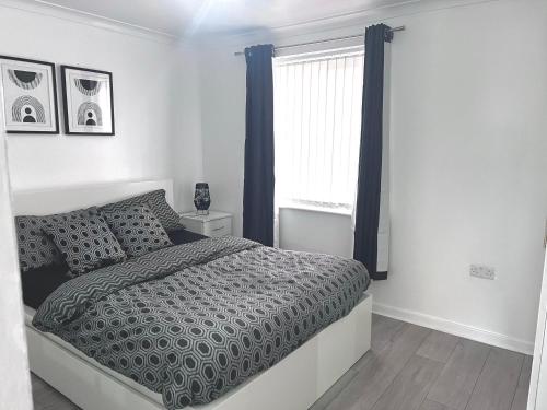 a white bedroom with a bed and a window at Shazeal Apartment Tipton in Ocker Hill