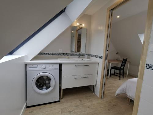 een badkamer met een wasmachine en droger in de kamer bij La terrasse in Fouesnant