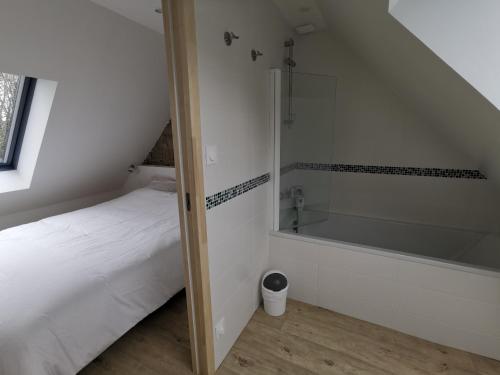 een badkamer met een douche, een bed en een bad bij La terrasse in Fouesnant