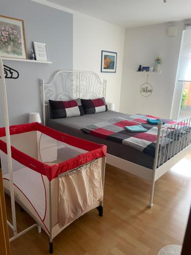 a bedroom with a bed and a crib in it at Pension Doreen Nieswand in Gamstädt