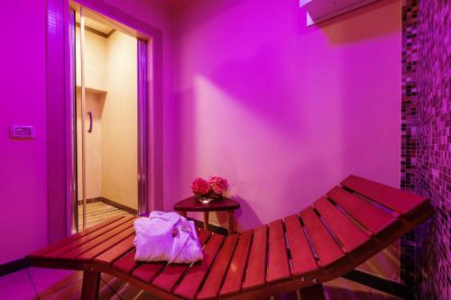 a purple room with a wooden bench and a table at Hotel Dei Vicari in Scarperia