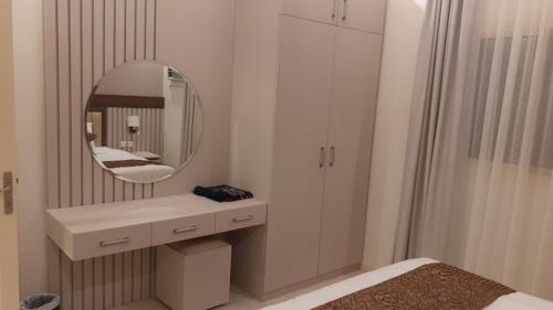 a white bathroom with a sink and a mirror at Nazik sweet - نازك سويت شقق فندقية in Tabuk