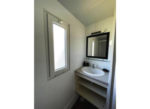 uma casa de banho com um lavatório e uma janela em Bungalow Breizh Vue em Plouha
