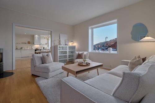 ein Wohnzimmer mit 2 weißen Stühlen und einem Tisch in der Unterkunft Luxurious w/ beautiful location in Bergen
