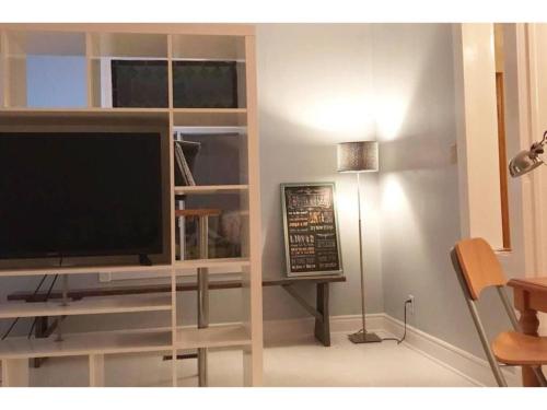 a living room with a television in a book shelf at Lovely Leslieville, exploring nature in the city in Toronto