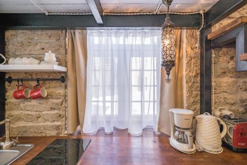 eine Küche mit einem Fenster und einem Mixer auf einem Holzboden in der Unterkunft Revelton Baku Studios in Baku
