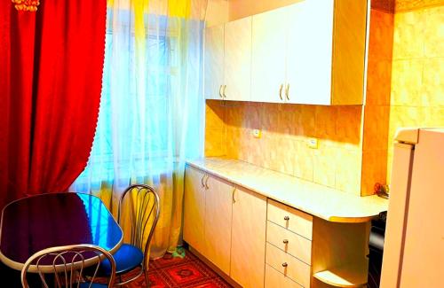 ムィコラーイウにあるСоборная-Sobornaya main streetのキッチン(青い椅子、赤いカーテン付)