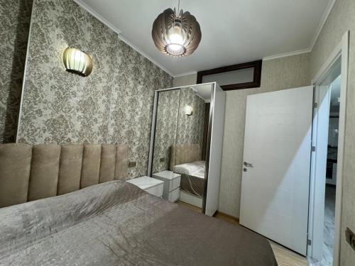ein Schlafzimmer mit einem großen Bett und einem Spiegel in der Unterkunft appartment GIORGI in Batumi