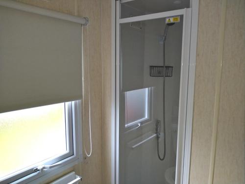 a shower in a bathroom with a window at Caravan for hire in Lancaster