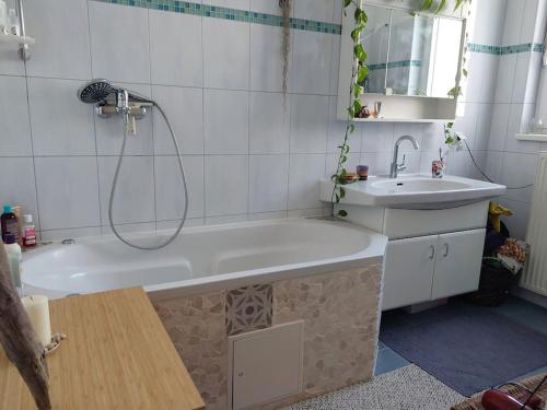 a bathroom with a bath tub and a sink at Schöne helle Wohnung mit Whirlpoolbadewanne in Graz