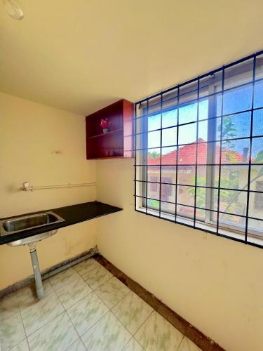 a kitchen with a sink and a large window at Acharya Compound in Udupi