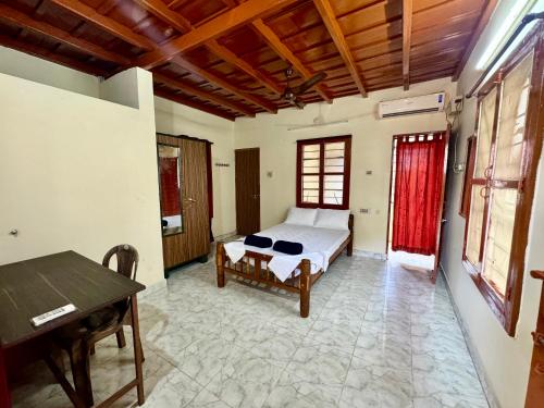 a bedroom with a bed and a table in it at Acharya Compound in Udupi