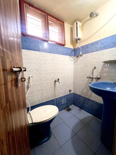 łazienka z toaletą i umywalką w obiekcie Acharya Compound w mieście Udupi