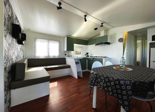 a living room with a table and a kitchen at Bungalow Breizh Vue in Plouha