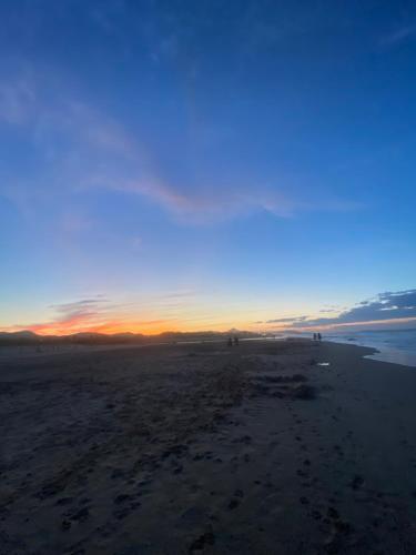 einen Strand mit Sonnenuntergang am Horizont in der Unterkunft Casa frente al mar con Vistas in Oliva