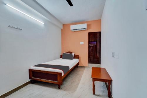 a small bedroom with a bed and a table at Collection O Jagadha Residency in Chennai