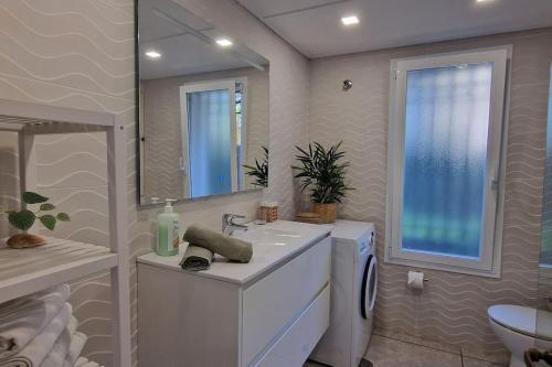 een badkamer met een wastafel, een toilet en een spiegel bij Luxe studio met ruim terras, vlak aan zee! in Sitio de Calahonda
