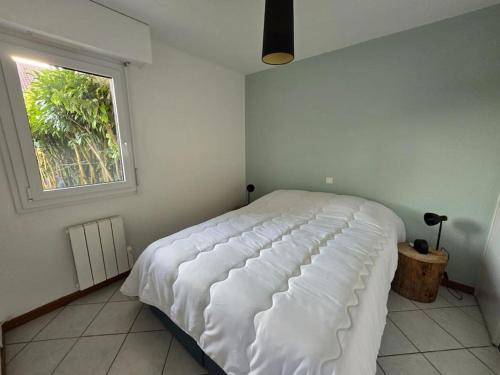 - un lit blanc dans une chambre avec fenêtre dans l'établissement La Violette, à Publier