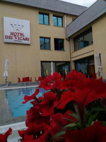 a hotel with red flowers in front of a swimming pool at Hotel Dei Vicari in Scarperia