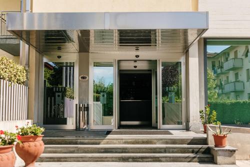 a front door of a building with stairs and plants at Hotel Dei Vicari in Scarperia
