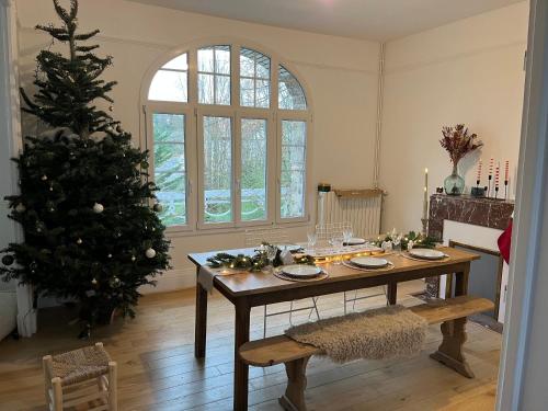 une salle à manger avec une table et un sapin de Noël dans l'établissement Le Cottage Clecy, à Clécy