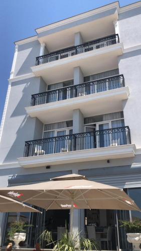 un edificio con una sombrilla delante de él en DIELL HOTEL, en Durrës