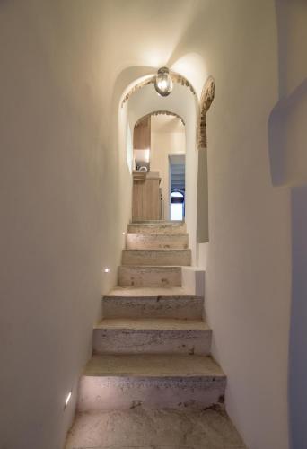 a stairway with an archway and stairs with a stairwayngth at Avgoustinos house in Chios