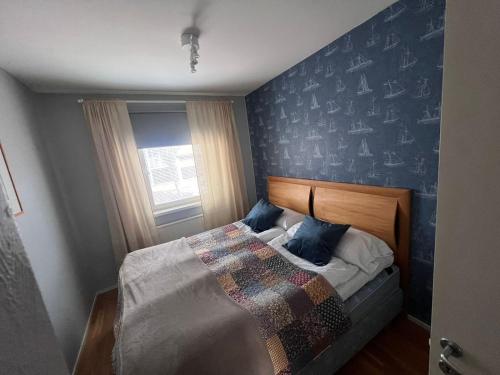 Un dormitorio con una cama con una pared de acento azul en M:Hamn Centrum, en Mariehamn