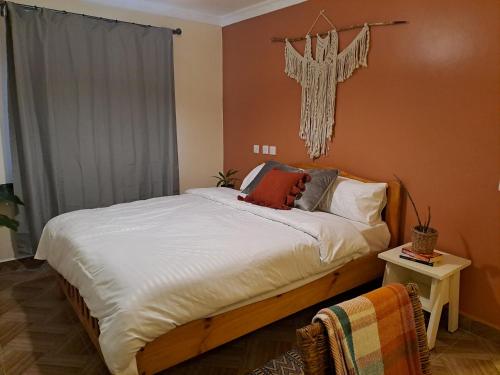 a bedroom with a bed with a cross on the wall at The Yala Home in Eldoret