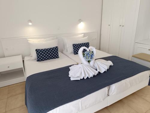 a white bed with a swan decoration on it at Nautilus City Studios & Apartments in Rhodes Town