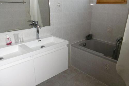 une salle de bain avec un lavabo blanc et une baignoire dans l'établissement 120m2-3 chambres parking et piscine à La Ciotat, à La Ciotat