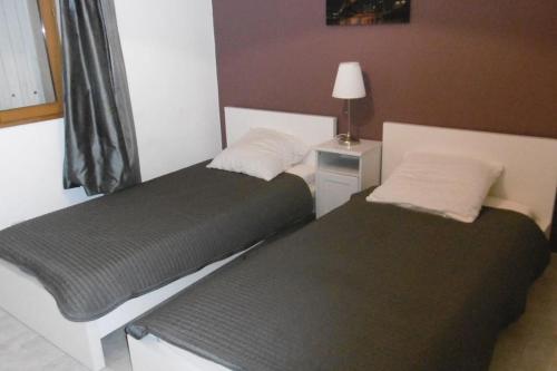 deux lits dans une chambre avec une lampe sur une table dans l'établissement 120m2-3 chambres parking et piscine à La Ciotat, à La Ciotat