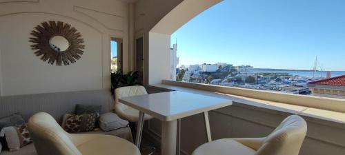 een kamer met een tafel en stoelen en een raam bij La Goelette - Palais des Festivals in Cannes