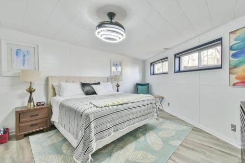 Un dormitorio blanco con una cama grande y una mesa en Luxurious Lake Lanier Home with Private Dock, en Flowery Branch