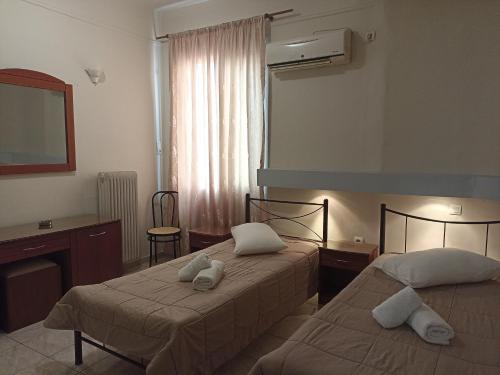 pokój hotelowy z dwoma łóżkami i biurkiem w obiekcie Elite Hotel w Atenach
