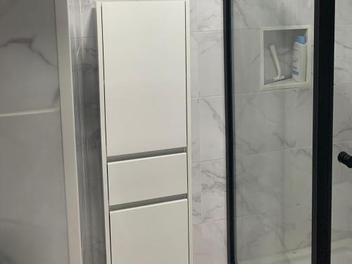 a glass shower door in a bathroom with marble at Beautiful 1-Bed Apartment in Aldeia de Paio Pires in Aldeia de Paio Pires