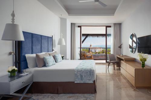 a bedroom with a large bed and a desk and a room at Kingdon of the Sun in Nuevo Vallarta 