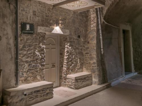 Habitación de piedra con puerta y pared de piedra en Avgoustinos house, en Chios