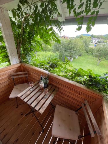 une terrasse couverte en bois avec une table et des chaises. dans l'établissement House Magdic Plitvice, à Grabovac