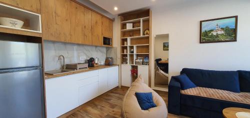 a kitchen and a living room with a blue couch at Studio apartmani Anika in Vrdnik