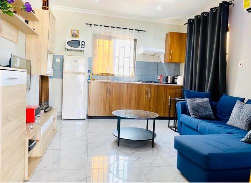 a living room with a blue couch and a table at Ferrez Apartment in Accra