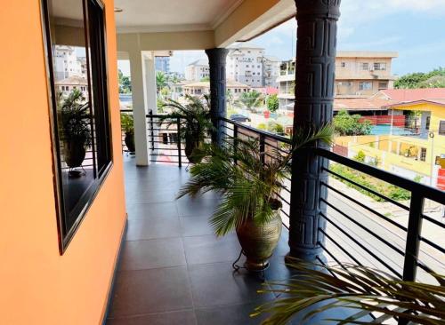 a balcony with potted plants and a view of a city at Ferrez Apartment in Accra