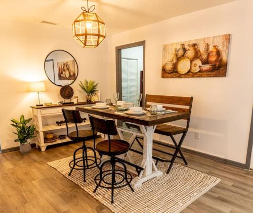 a dining room with a table and chairs and a mirror at Upscale Ybor House with Outdoor Living Space in Tampa